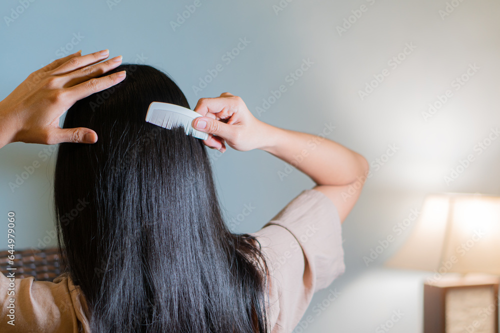Fototapeta premium Young woman brushing healthy hair