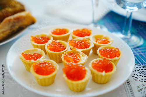 tartlets with red caviar on a white plate.