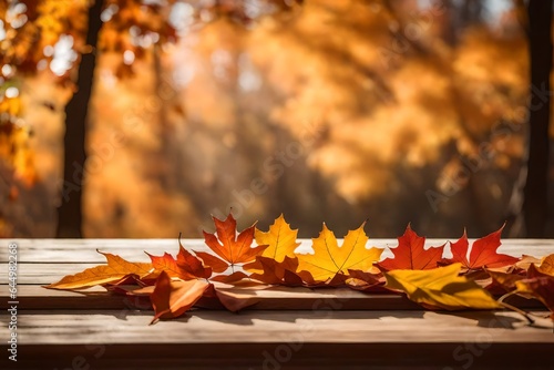Empty wooden table top podium decorated with dry autumn leaves  blurred background of autumn plants