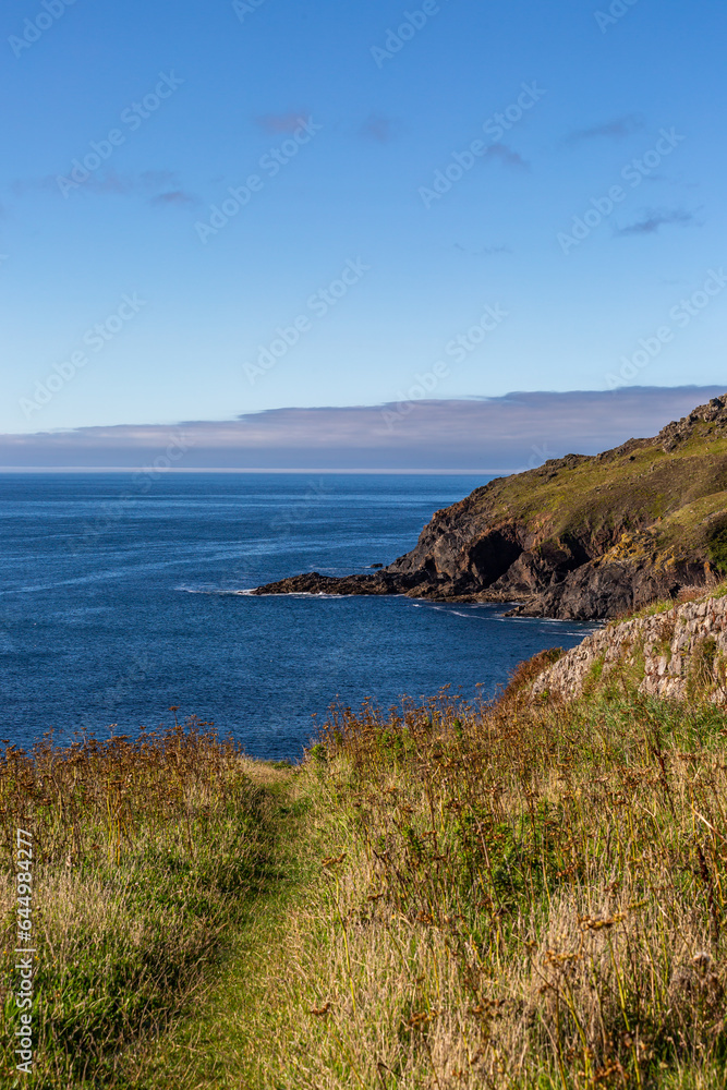 The Cornish coastline near Porth Ledden, with a blue sky overhead
