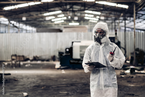 Scientist wear Chemical protection suit check danger chemical, working at dangerous zone in Red and White Lines of barrier tape. Red and white Hazardous restricted area factory safety worker industry © kanpisut