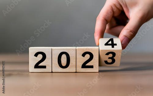 Cube turns from 2023 to 2024 on wooden table