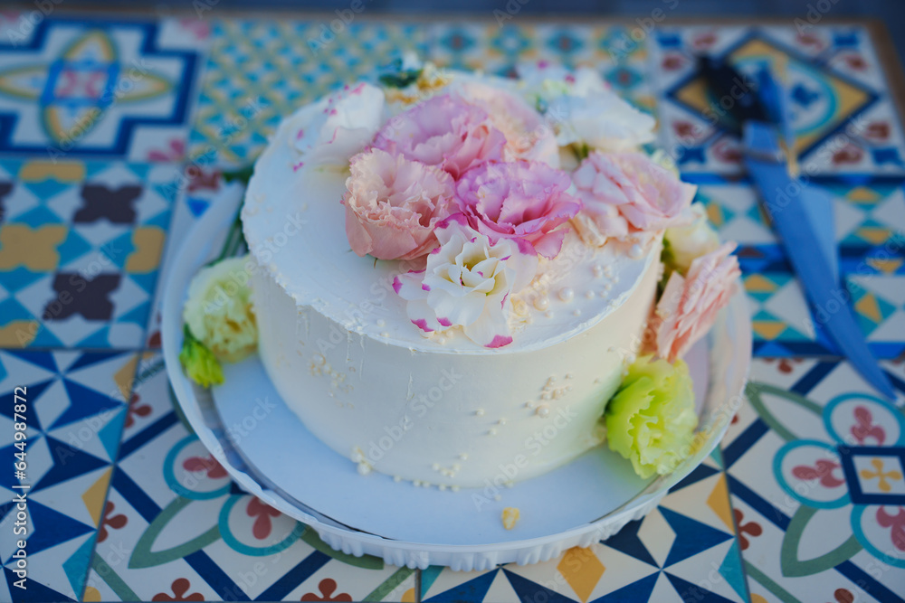 Classic white cake decorated with pink and white fresh flowers. Classic white cake decorated with pink and white fresh flowers.