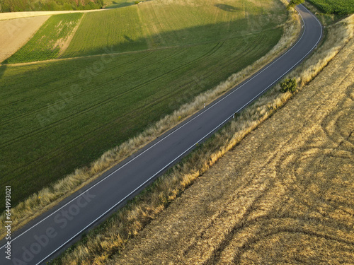 Aerial view of a road between fields in the countryside 