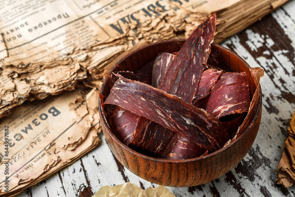 Jerky, Sujuk, Basturma, dried cured smoked sausage in bowl in wooden