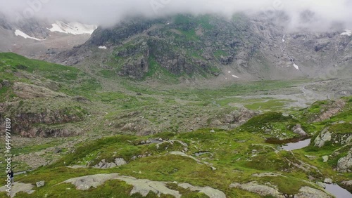 4K aerial drone view of Gries Glacier melting ice. Swiss Alps climate change, global warming effects. Griessee mountain lake near Susten Pass, Switzerland in summer.  photo