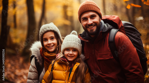 A happy family enjoys a hike through colorful autumn leaves background with empty space for text 