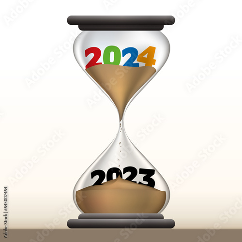 Concept du temps qui passe et du passage à la nouvelle année, avec un sablier qui présente 2024 en faisant disparaître 2023