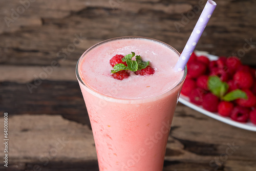 Raspberry smoothie red colorful fruit juice milkshake blend beverage healthy high protein the taste yummy In glass drink episode morning on a wooden background.