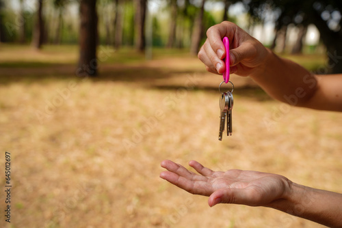 Real estate agent giving keys for a new house. Purchase sale of a property. Keys to lock the apartment