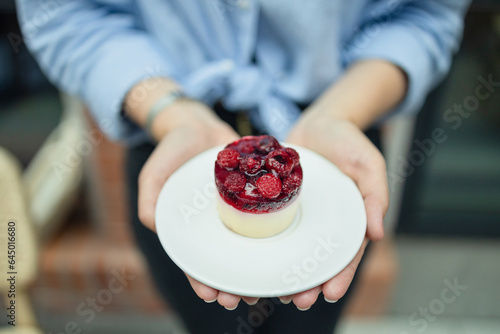 Woman holding birthday berry organic healthy vegetarian  cake against blurred background, closeup. Space for text. High quality photo