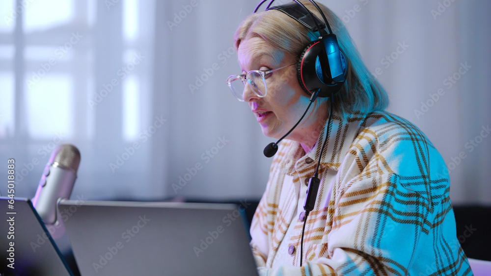 A concentrated senior woman is playing a game online while vlogging about her gaming hobby A concentrated senior woman is playing a game online while vlogging about her gaming hobby