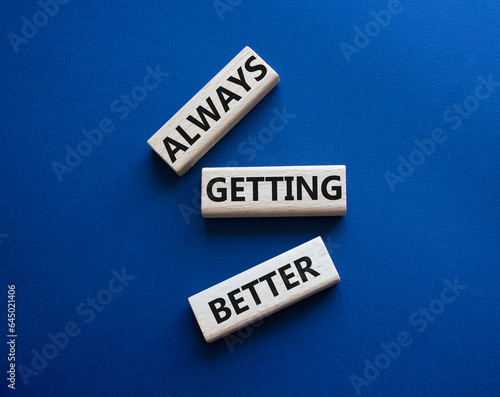 Always getting better symbol. Wooden blocks with words Always getting better. Beautiful deep blue background. Business and Always getting better concept. Copy space.