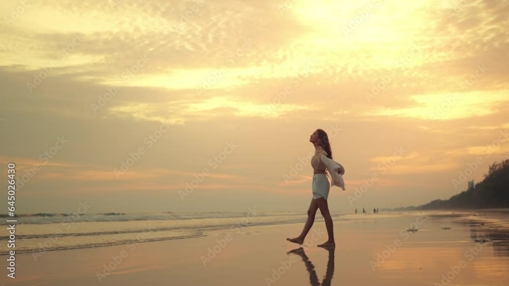 Slow motion of young asian woman with freedom on the sea beach at golden sunset, Female tourist on seaside summer vacation, Go Everywhere. Slow motion of young asian woman with freedom on the sea beach at golden sunset, Female tourist on seaside summer vacation, Go Everywhere.