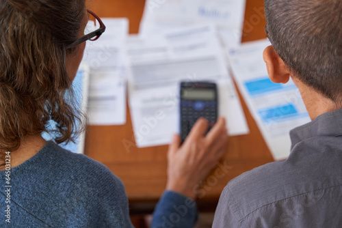 High angle shot Senior business couple managing balance and using calculator with bills and paperwork