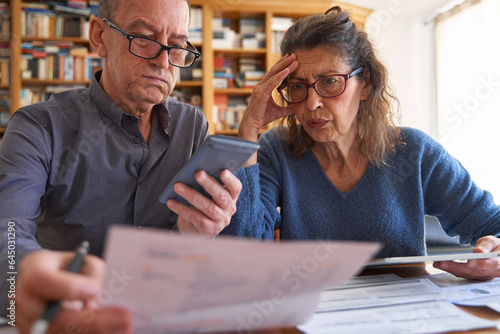 Senior couple with tablet and calculator anxious while managing bills and taxes. Domestic life budget and bank balance