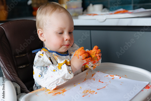 Finger painting. Cute little boy painting with fingers at home. Close-up of child s hand in colorful paints. Early education concept. Sensory play. Development of fine motor skills.