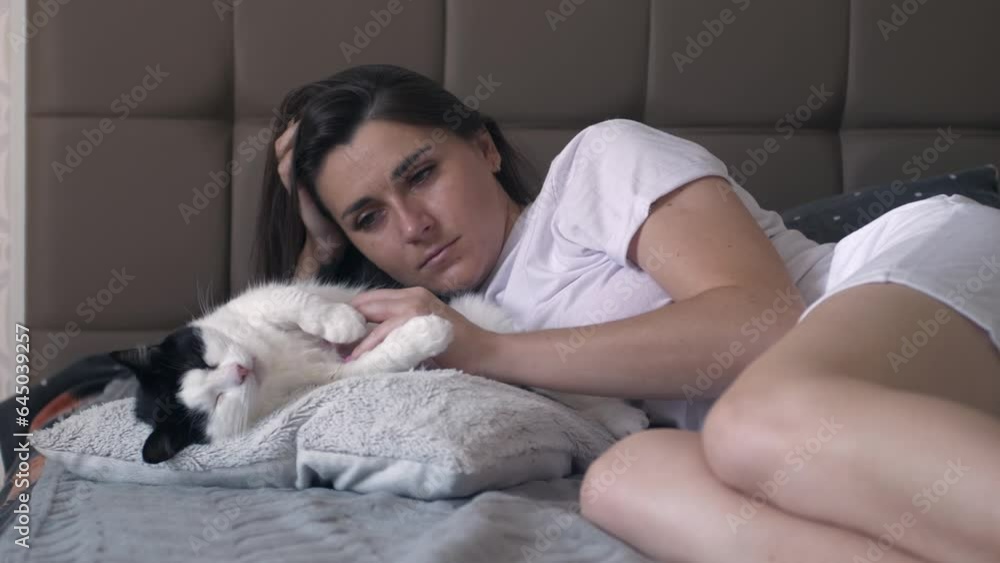 Caucasian woman hugging and play with her cat with happiness at home. Attractive beautiful female lying down on bed with her adorable pet Caucasian woman hugging and play with her cat with happiness at home. Attractive beautiful female lying down on bed with her adorable pet