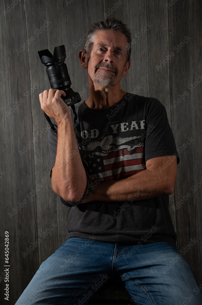 Mature male photographer portrait with DSLR camera Mature male photographer portrait with DSLR camera