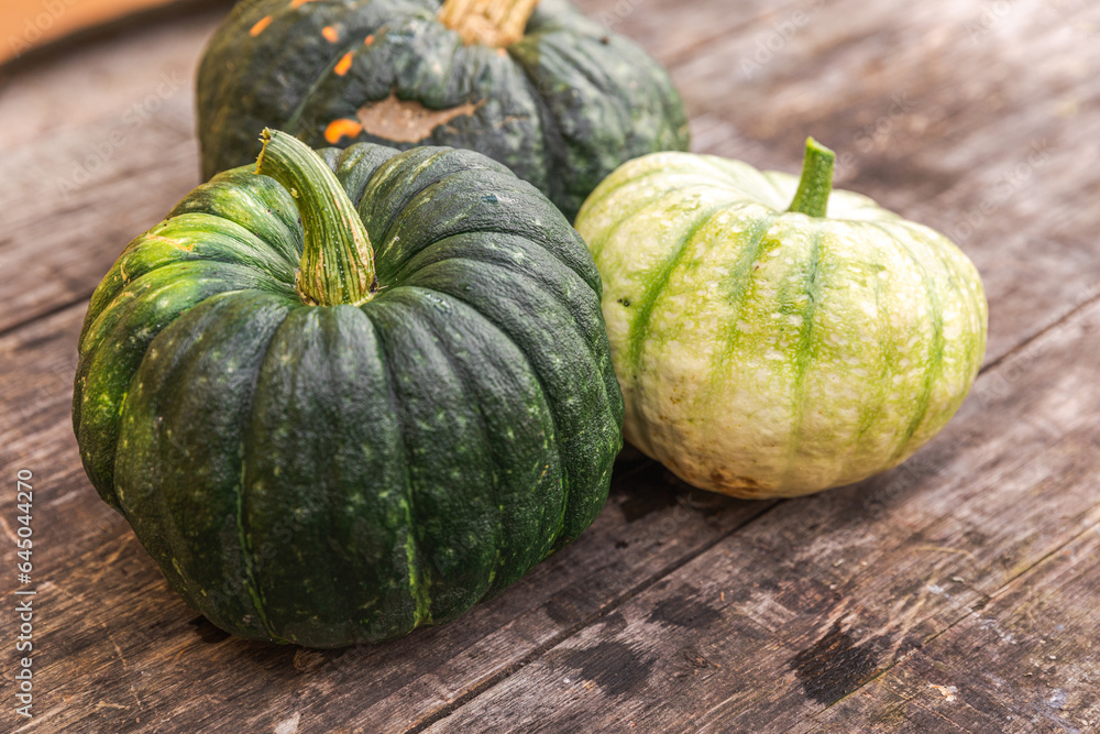 Autumnal Background. Natural autumn fall view pumpkins on wooden background. Inspirational october or september wallpaper. Change of seasons ripe organic food concept. Halloween party Thanksgiving day Autumnal Background. Natural autumn fall view pumpkins on wooden background. Inspirational october or september wallpaper. Change of seasons ripe organic food concept. Halloween party Thanksgiving day