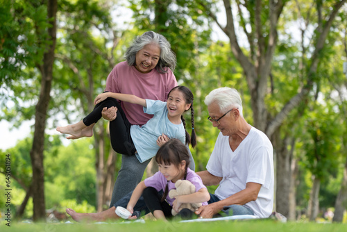 Happy Asian family children having fun and playing with her grandparents in the park © surachetkhamsuk