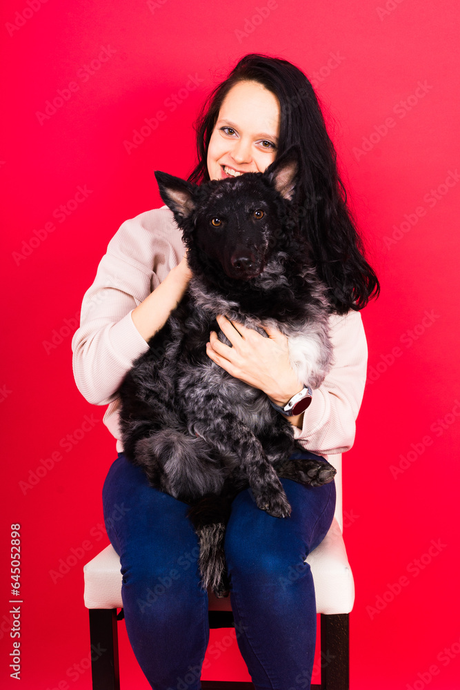 Happy brunette lady in casual wear hugging mudi pet dog, studio background. Happy brunette lady in casual wear hugging mudi pet dog, studio background.