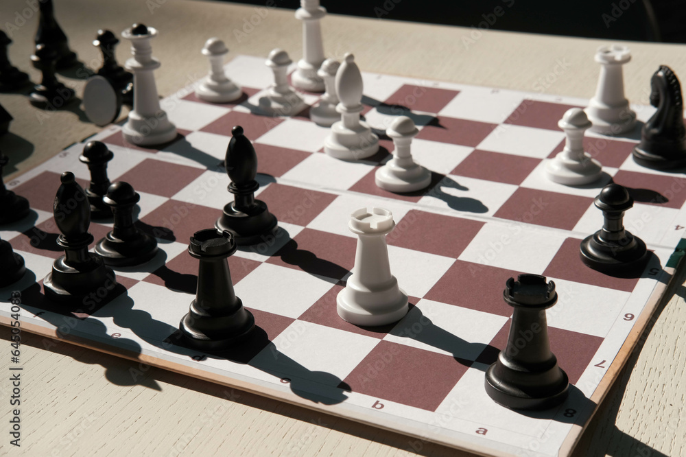 Chessboard and white figures. Blur and selective focus. Chessboard and white figures. Blur and selective focus.