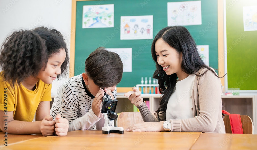 Teacher teach boy girl students science lab , back to school. Beautiful asian little girl looking at a microscope in a classroom. Selective focus on microscope. Education science project concept Teacher teach boy girl students science lab , back to school. Beautiful asian little girl looking at a microscope in a classroom. Selective focus on microscope. Education science project concept