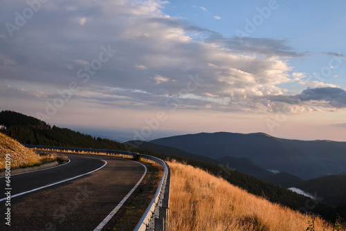 An orange sunset over the Carpathian Mountains with a view of the Transalpina road.Parâng Mountains, Romania