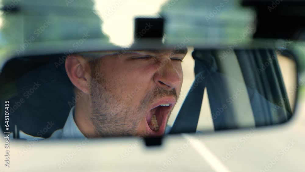 Tired man driving a car. Guy looking at the road and yawning. Close up. Right hand drive car. Lifestyle, travel concept. Real time Tired man driving a car. Guy looking at the road and yawning. Close up. Right hand drive car. Lifestyle, travel concept. Real time