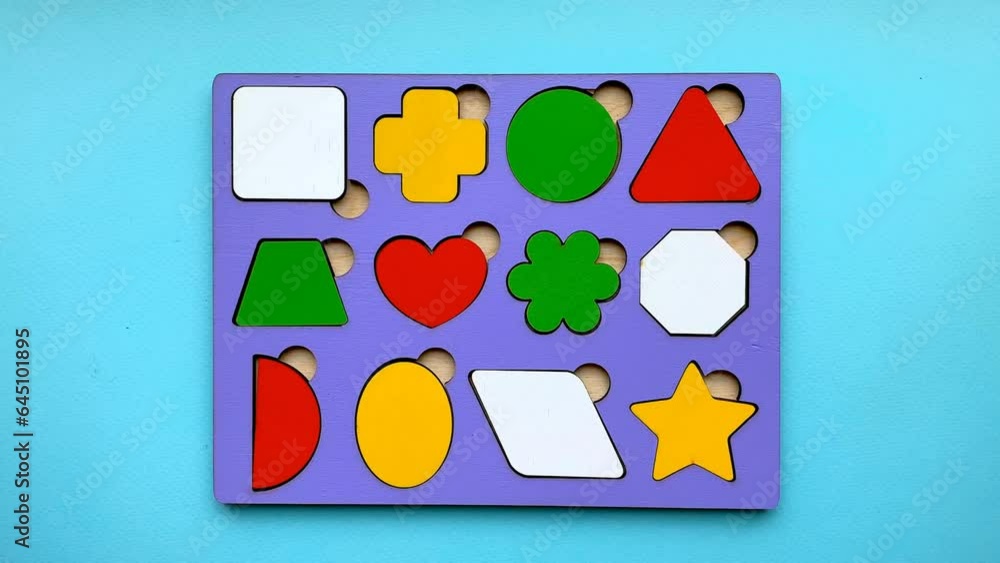 Close-up of an educational toy with inserts, with female hands demonstrating assembly and disassembly