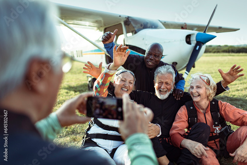 Group of senior friends taking a selfie after skydiving for the first time and completing their bucket list photo