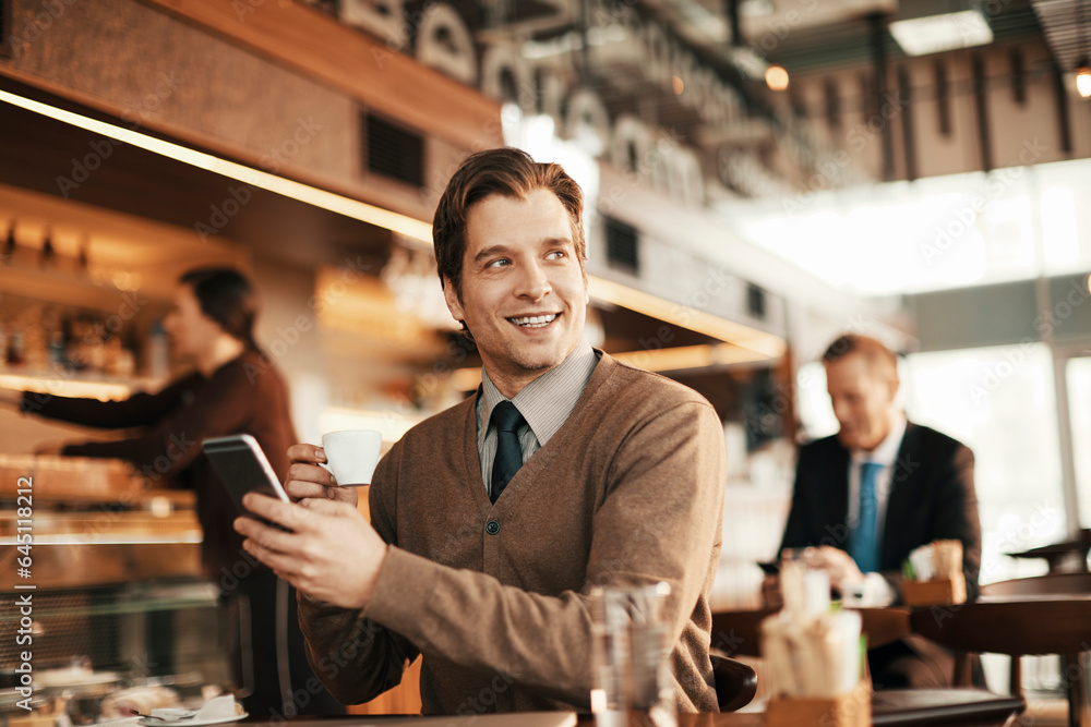Young businessman using a smartphone while having coffee in a cafe