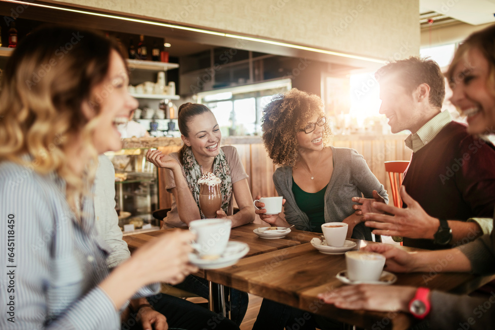 Young and diverse group of friends talking while having coffee together in a cafe Young and diverse group of friends talking while having coffee together in a cafe