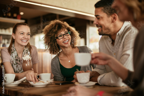 Young and diverse group of people talking and having coffee together in a cafe