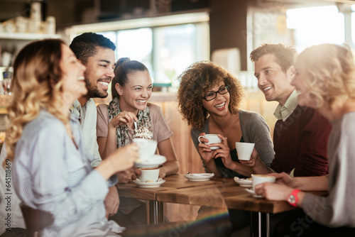 Young and diverse group of people talking and having coffee together in a cafe