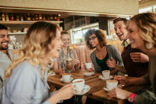 Young and diverse group of friends talking while having coffee together in a cafe