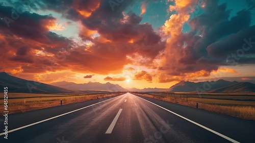 A vast asphalt road with a dark floor, leading towards a horizon showcasing sunset clouds and the evening sky.