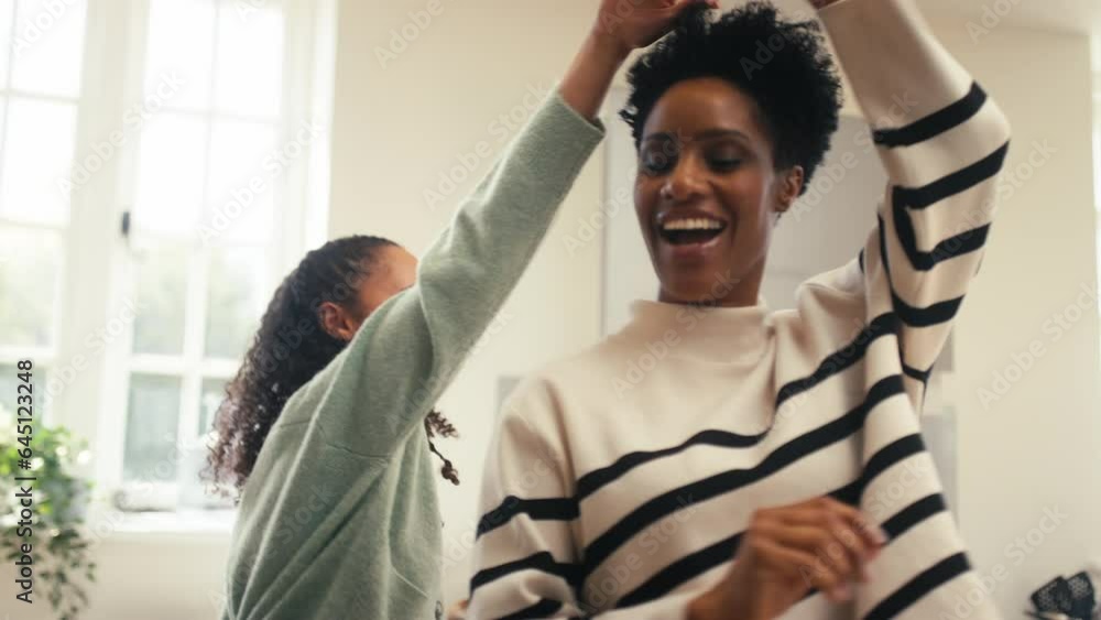 Mature mother with teenage daughter at home in kitchen having fun dancing together - shot in slow motion Mature mother with teenage daughter at home in kitchen having fun dancing together - shot in slow motion