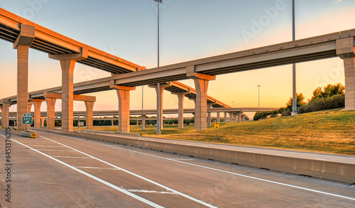Elevated highways crossing on top of each others at sunset. Modern roads and bridges in Texas at golden hour