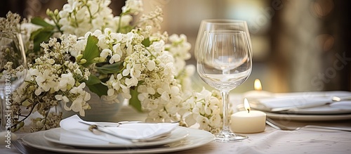 Elegant dinner table adorned with white flowers and cutlery for a beautiful festive setting.