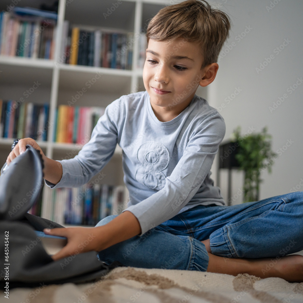 Small boy pupil child prepare his backpack for first day of school Small boy pupil child prepare his backpack for first day of school