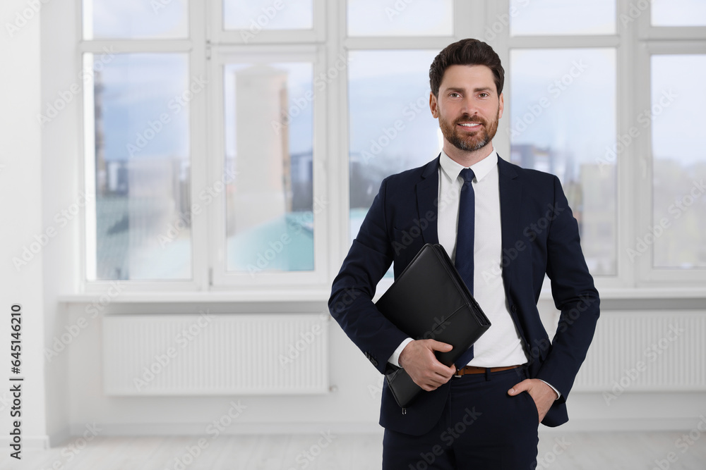 Happy real estate agent with leather portfolio indoors. Space for text Happy real estate agent with leather portfolio indoors. Space for text