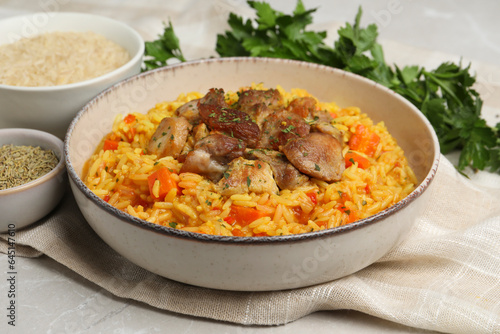 Delicious pilaf with meat and ingredients on light grey table, closeup
