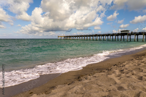 Venice fishing pier in Florida on sunny summer day. Bright seascape with surf waves crashing on sandy beach © bilanol