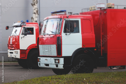 Fire fighting equipment in the city, with red fire engine truck during fire fighting operation in the city streets, vehicle and firefighters extinguish blaze, emergency and rescue service vehicle