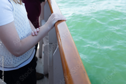 Teen girl  with hands on the railing of a boat on the starboard side boating in Lake Ontario  © Greg