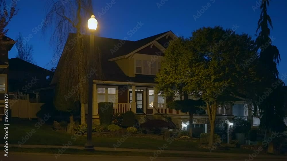 Establishing shot of two story stucco luxury house with garage door, big tree and nice landscape at night in Vancouver, Canada, North America. Night time on Apr 2023. ProRes 422 HQ. Establishing shot of two story stucco luxury house with garage door, big tree and nice landscape at night in Vancouver, Canada, North America. Night time on Apr 2023. ProRes 422 HQ.