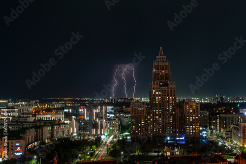 Astana, Kazakhstan, August, 2023. Night view of the skyscraper of the central street of the capital during a thunderstorm with lightning.