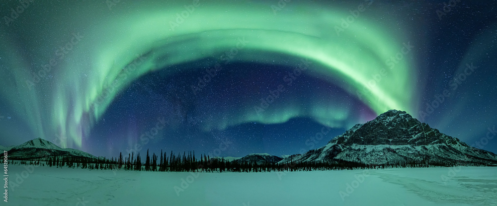 A panorama of the aurora borealis or northern lights over the Brooks Range of northern Alaska, USA. 
